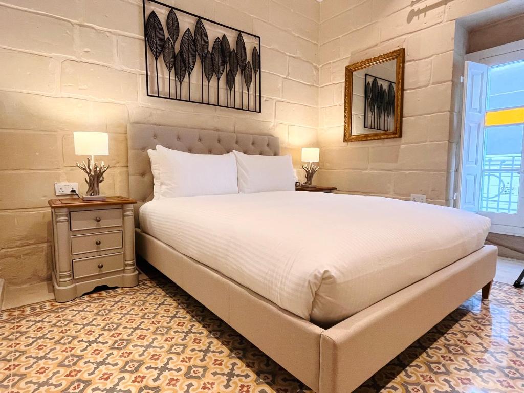 a bedroom with a large bed and two night stands at Typical Maltese Maisonette in St.Julians in St. Julianʼs