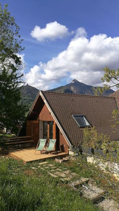 ein Haus mit einer Terrasse mit zwei Stühlen darauf in der Unterkunft le beau coin, unique et magique 