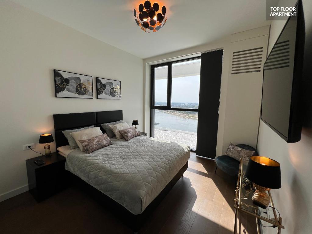 - une chambre avec un lit et une grande fenêtre dans l'établissement BW TERRACE top floor apartments with river view & self check-in, à Belgrade