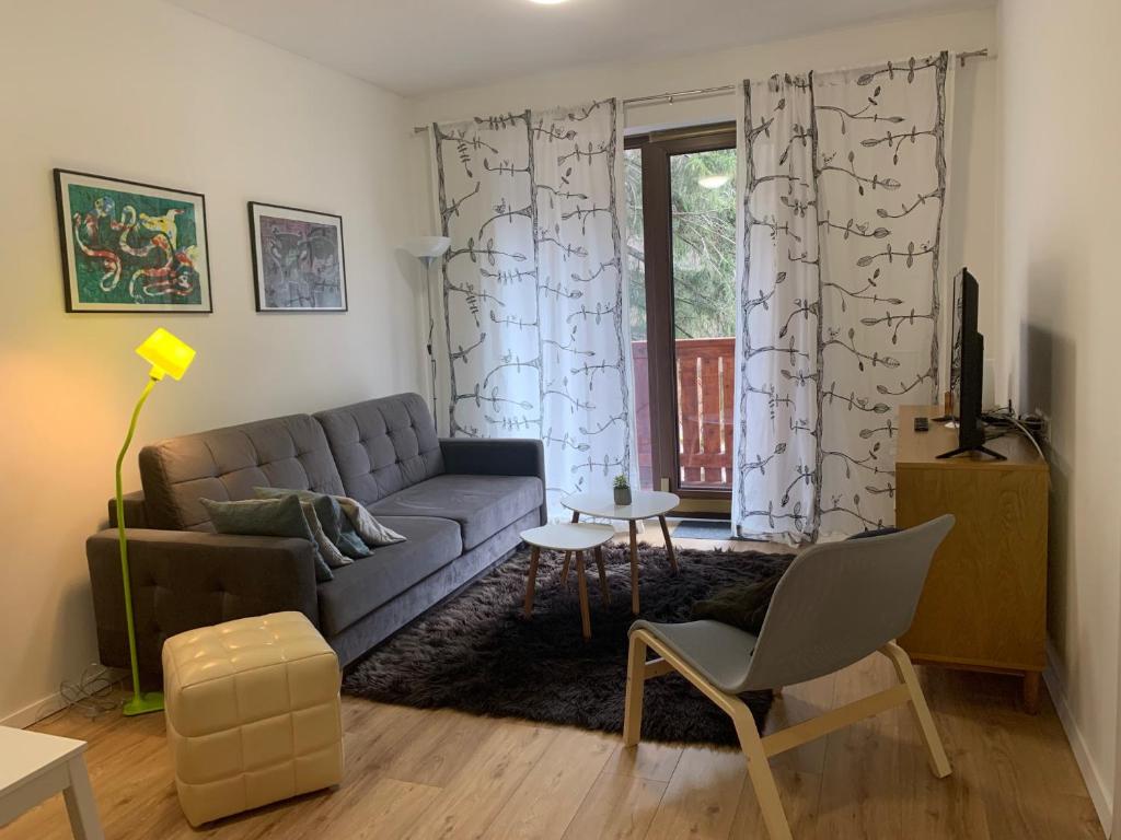 uma sala de estar com um sofá e uma mesa em Apartmán Jeleň Chopok Juh-Trangoška em Tale