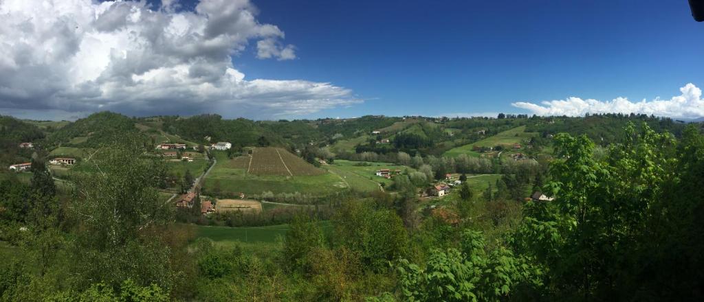- une vue sur une colline verdoyante avec des arbres et des maisons dans l'établissement La Contea, à Acqui Terme