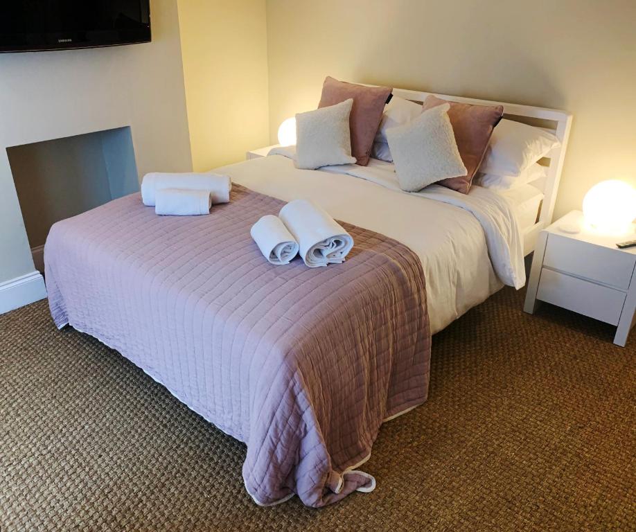 a bedroom with a large bed with two towels on it at Cosy Central Hideaway in St. Leonards