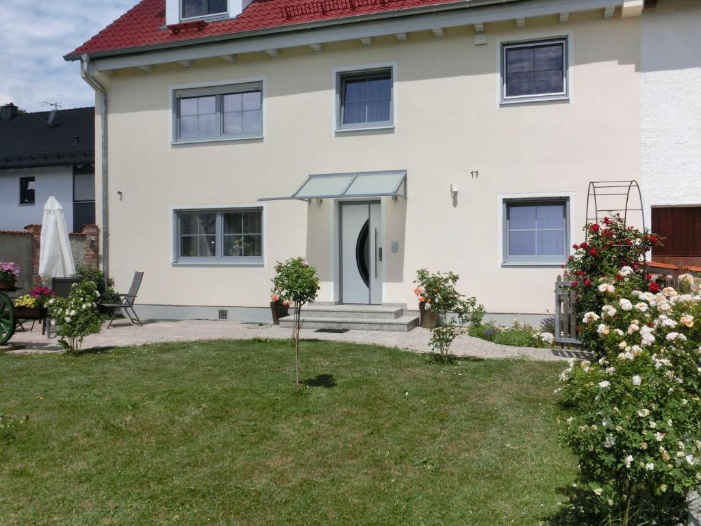 una casa blanca con un patio de césped en Weberhof, en Egenhofen