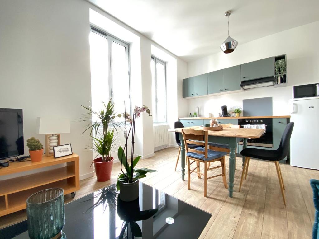 a kitchen and living room with a table and chairs at Le Vichatel - Charmant T3 en centre ville proche de place Gaillard in Clermont-Ferrand