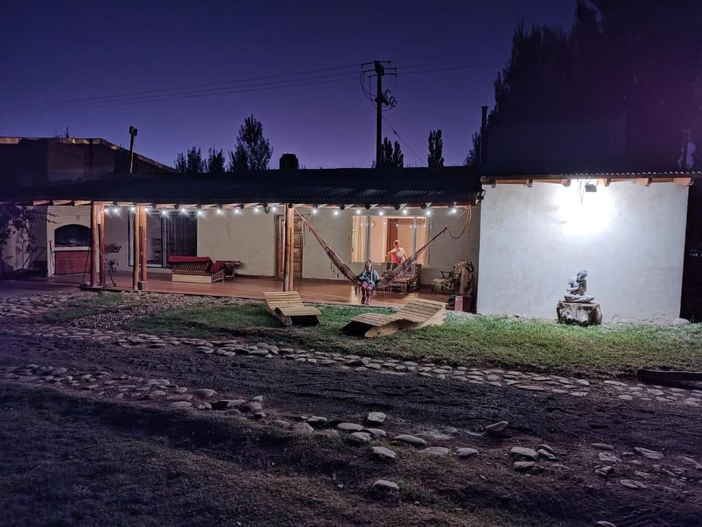 a house with lights on the side of it at night at La Posada de Buda in Malargüe