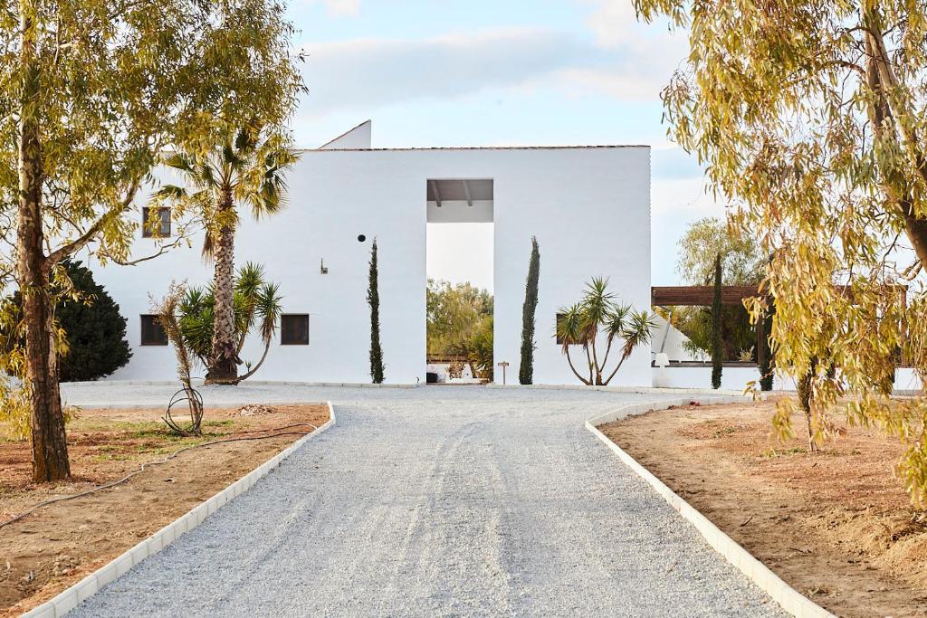 eine Straße vor einem weißen Gebäude in der Unterkunft Finca las Calmas boutique hotel & retreats in Moraleda de Zafayona