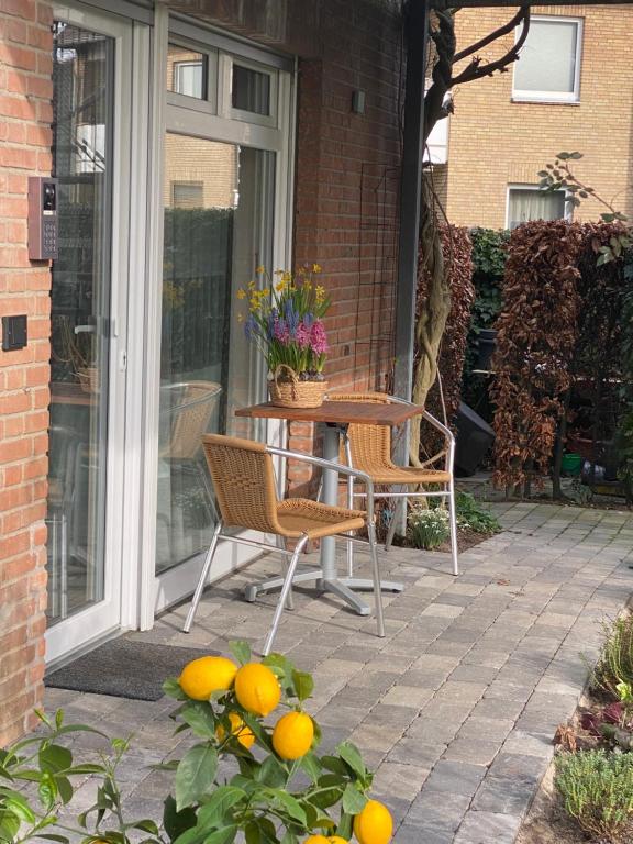 eine Terrasse mit einem Tisch, Stühlen und Orangen in der Unterkunft Komfort-Apartment BIRKE in Tönisvorst