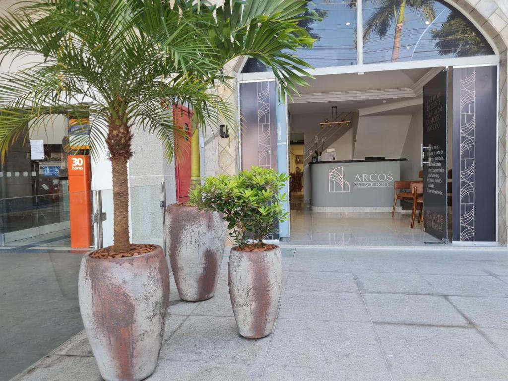 three large metal pots with trees in front of a building at Arcos Palace Hotel in Arcos
