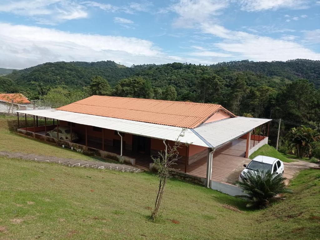 een huis met een auto ervoor geparkeerd bij Chácara Biritiba Mirim, Bairro Nirvana - Mogi das Cruzes in Biritiba-Mirim