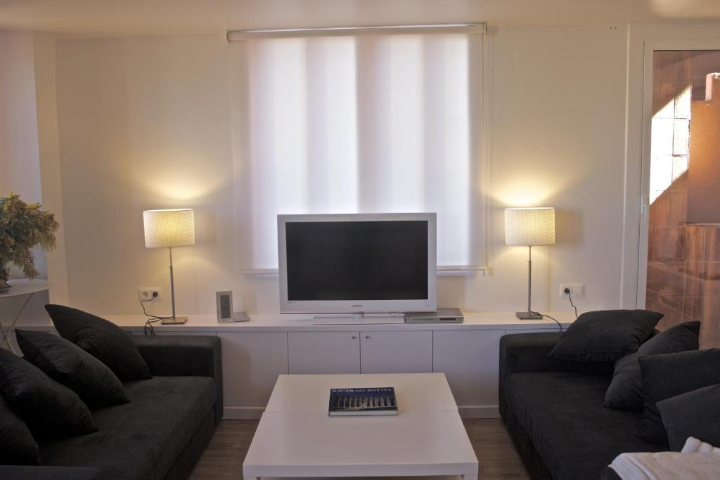 sala de estar con sofá y TV en Apartamento Walden, en Sant Just Desvern