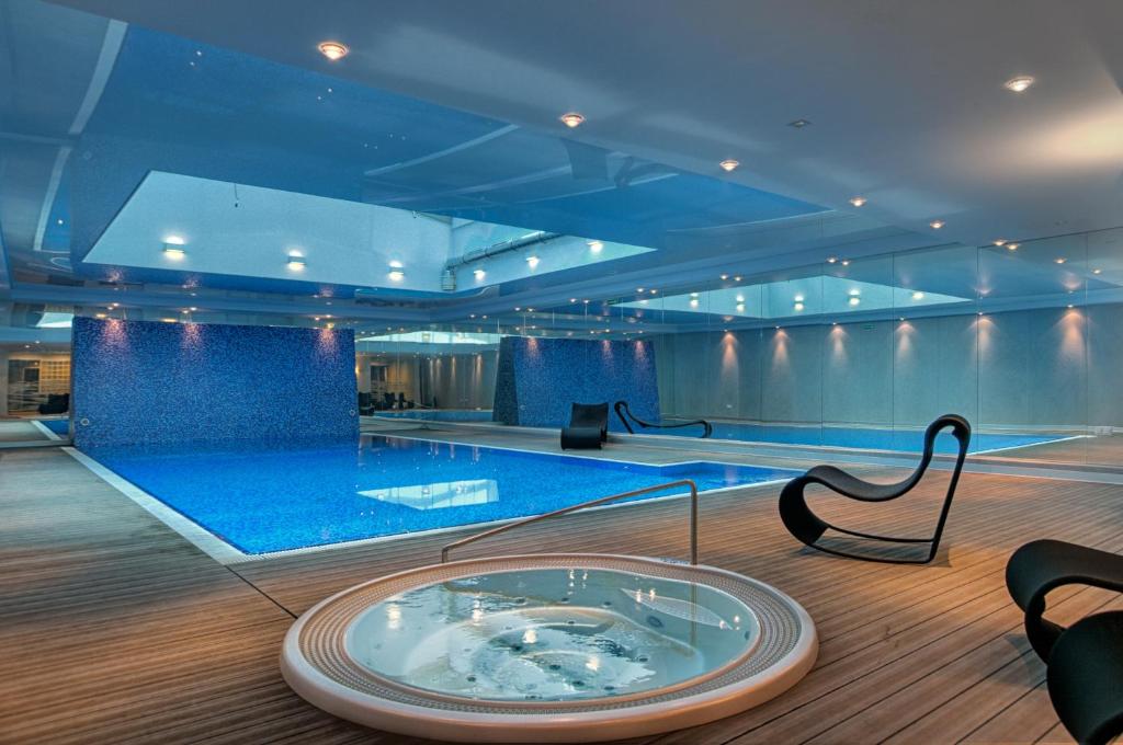 a swimming pool with a glass table in a room at Apartamenty Apartinfo Waterlane in Gdańsk