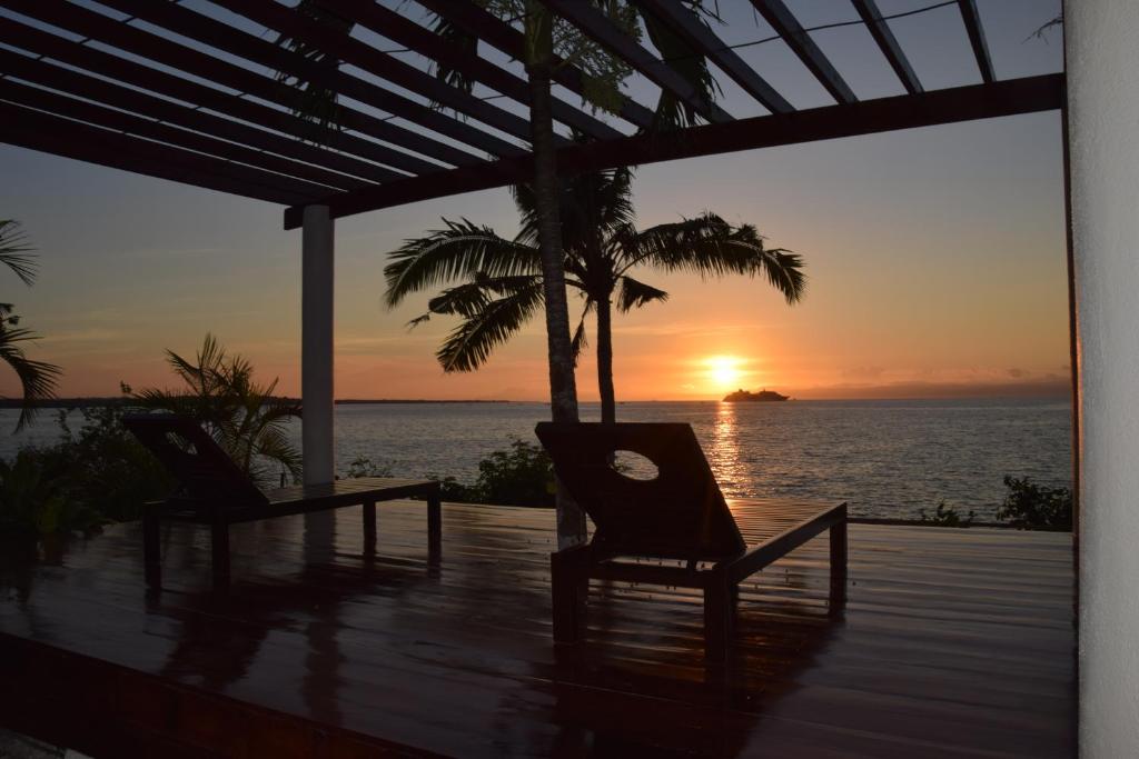 a couple of chairs sitting on a deck watching the sunset at Kasagpan in Tagbilaran City