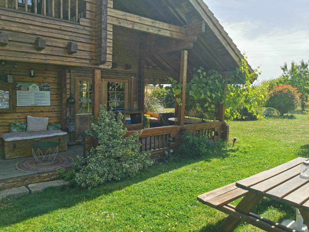 Cabaña de madera con porche y mesa de picnic en La bulle des champs en Champmotteux