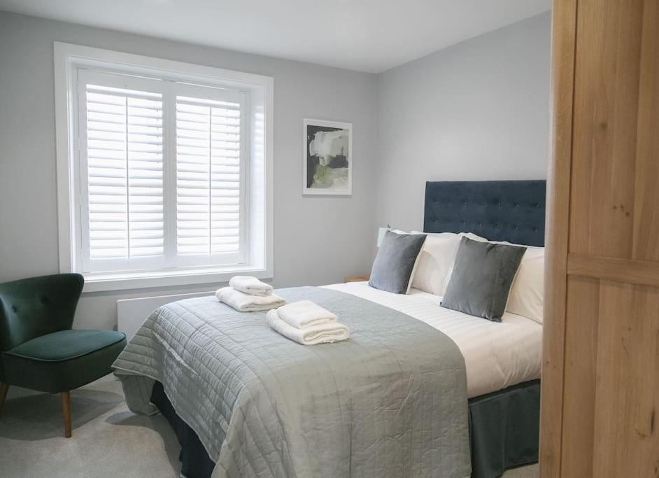 ein Schlafzimmer mit einem Bett, einem Stuhl und einem Fenster in der Unterkunft 45a Oxford Street in Harrogate