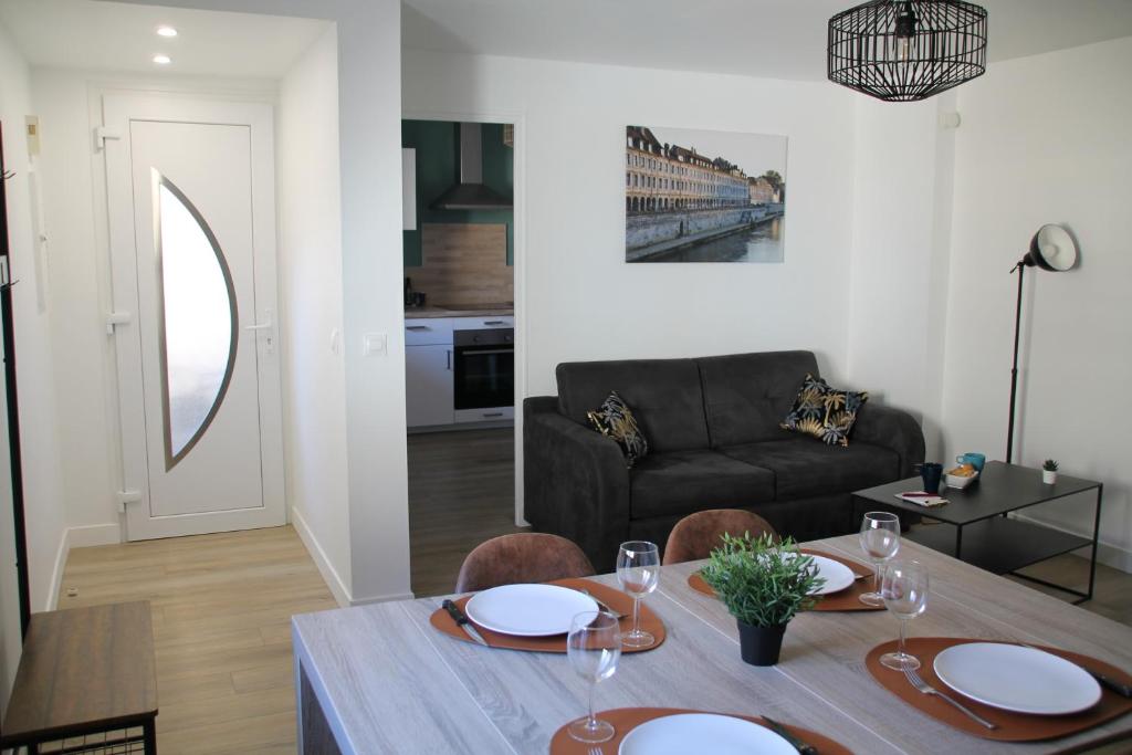 sala de estar con mesa y sofá en Besançon appartement T2 sur cour intérieure proximité gare en Besançon