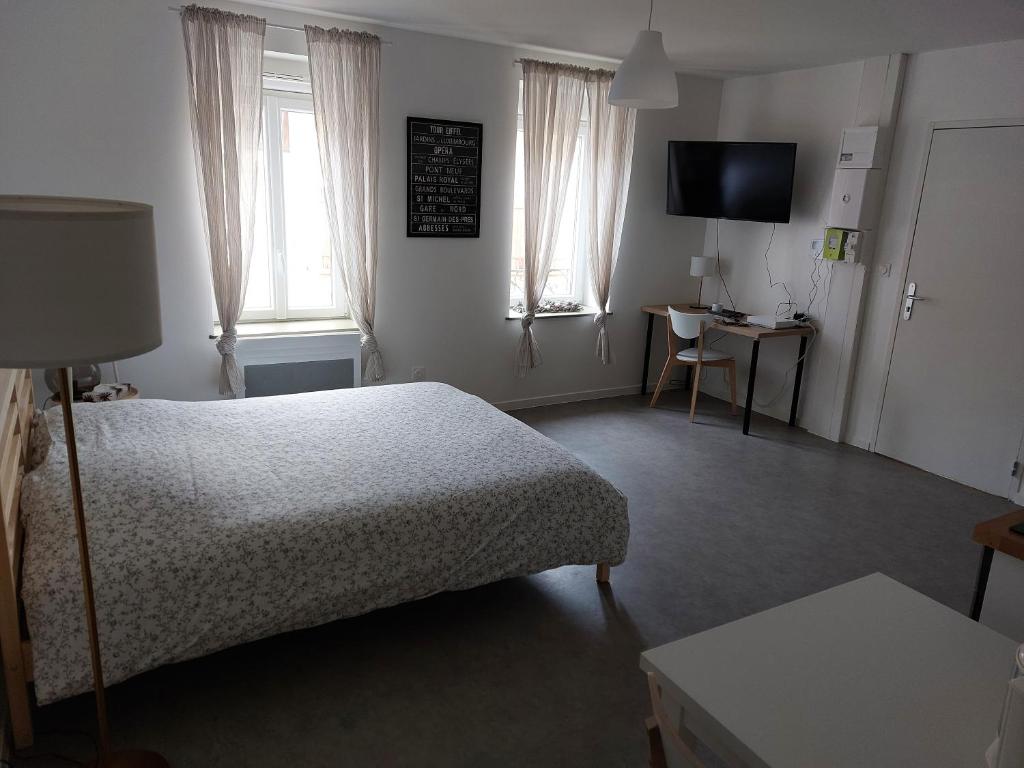 1 dormitorio con cama, mesa y TV en Studio tout confort, en Corny-sur-Moselle