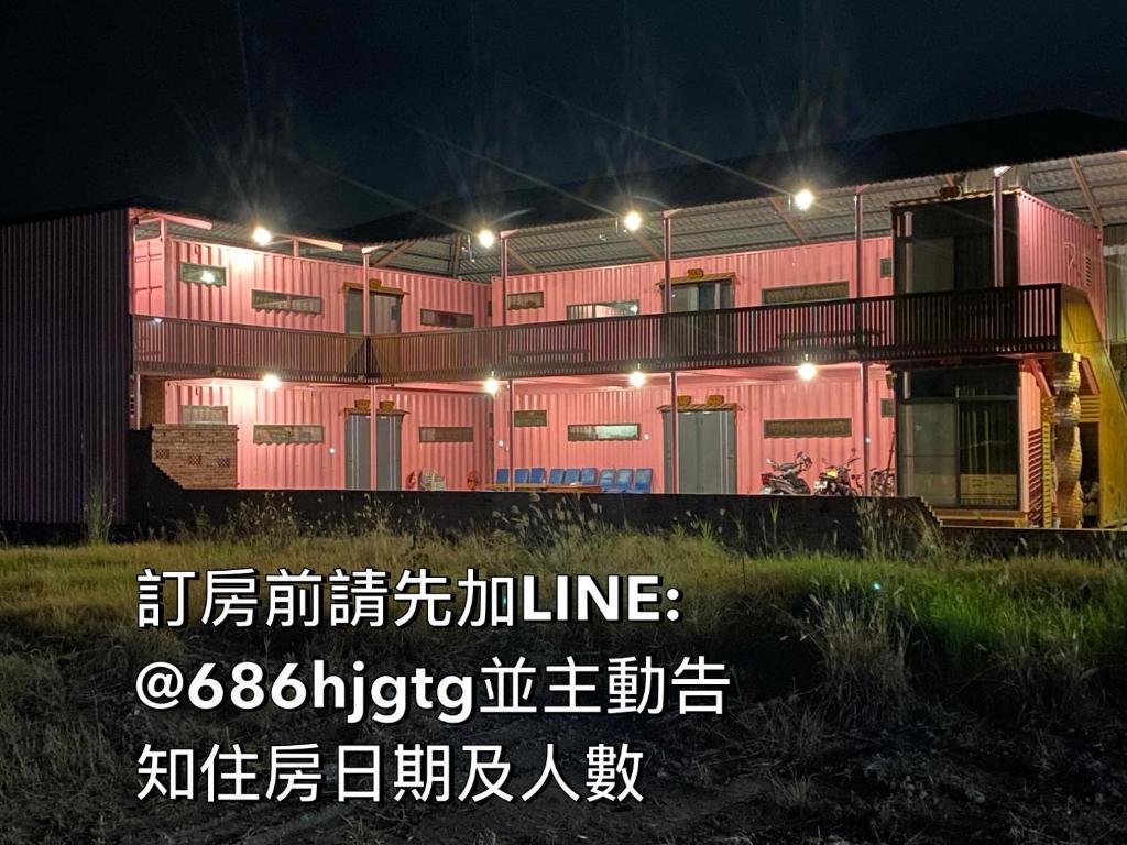a building with a sign in front of it at night at Zhenan Pink Panther in Linbian