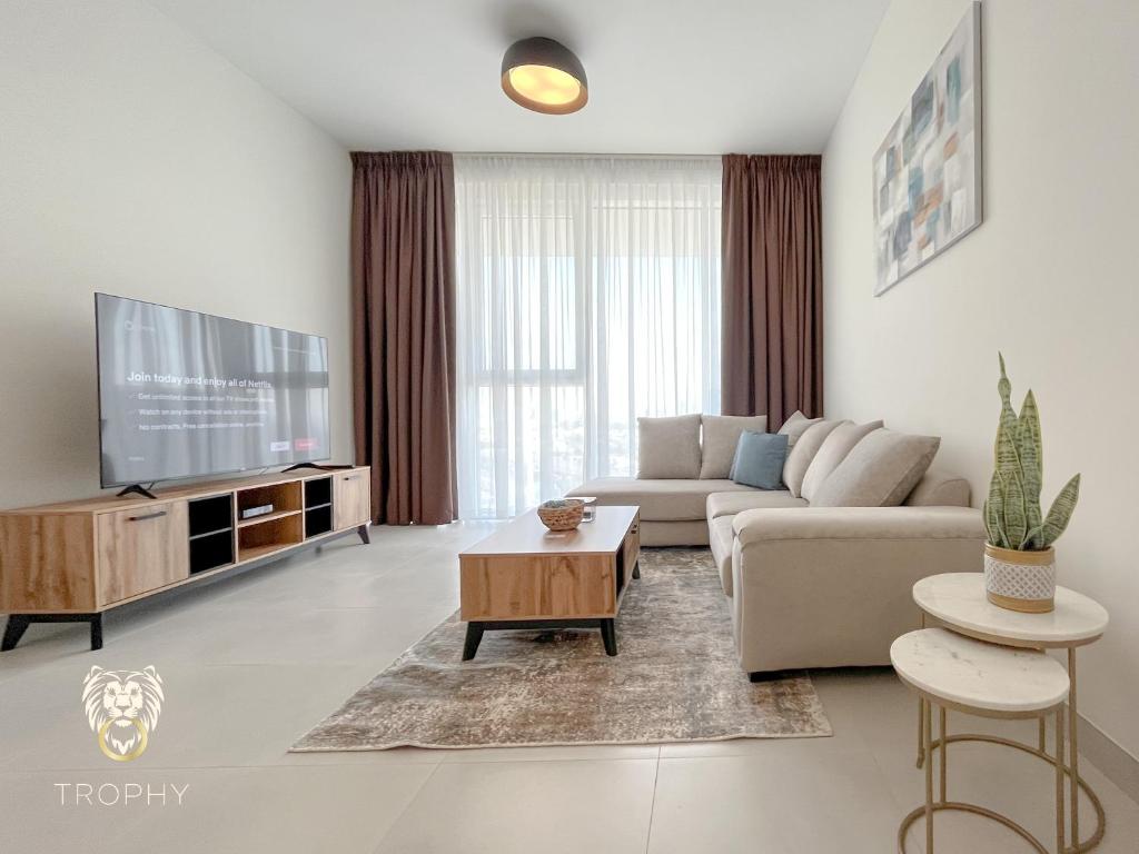 a living room with a couch and a tv at Luxury 1BR Apt with Unobstructed Dubai Frame View in Dubai