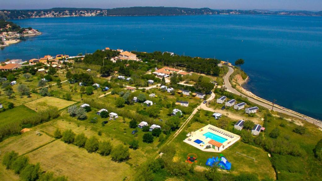 Saint-Mitre-les-Remparts的住宿－Camping Tikayan Félix de la Bastide，享有岛屿的空中景致,设有度假村和游泳池