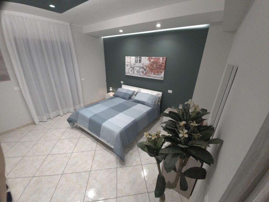 - une chambre avec un lit et une plante dans l'établissement Montalbano Sweet Home, tra l' Etna e il mare, à Fleri