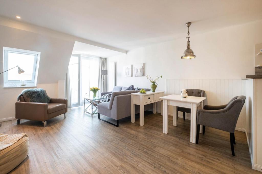 a living room with a couch and a table and chairs at Weisse Villa Apartment 3 1 Hafenkante in Büsum