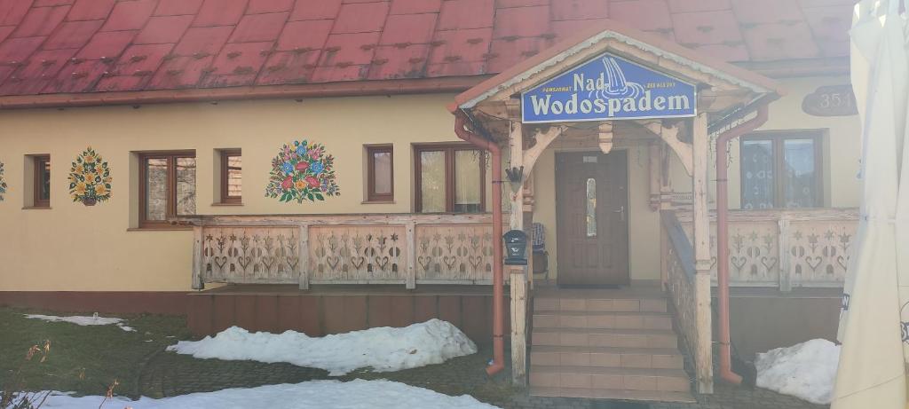 a house with a sign on the front of it at Domek nad wodospadem in Zakopane