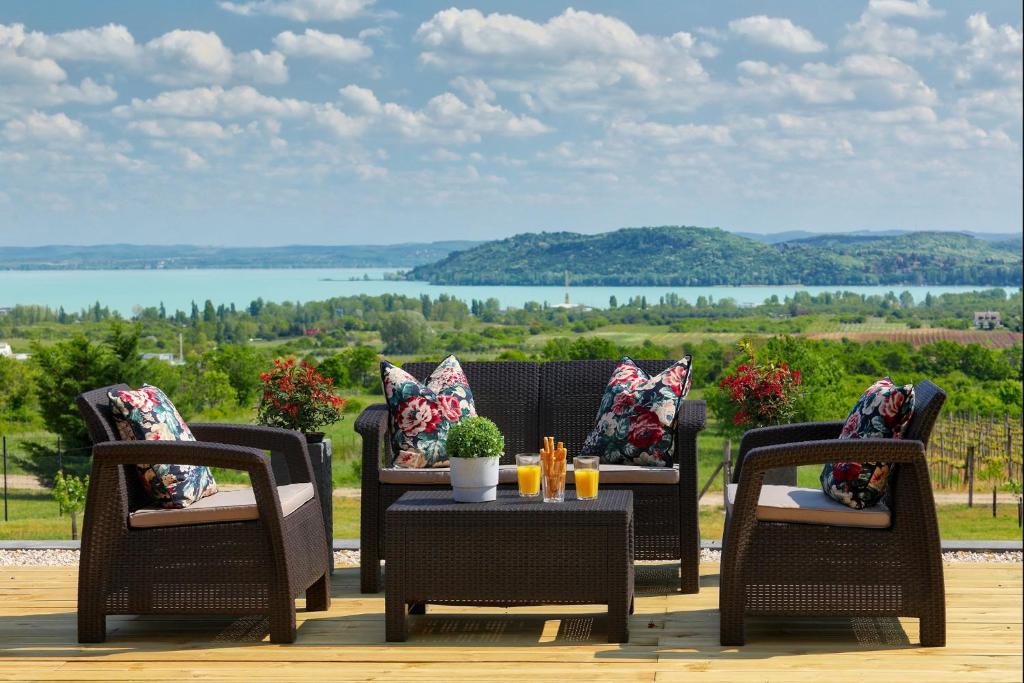 a patio with wicker chairs and a table with a view at Lotti Residence Exclusiv in Balatonfüred