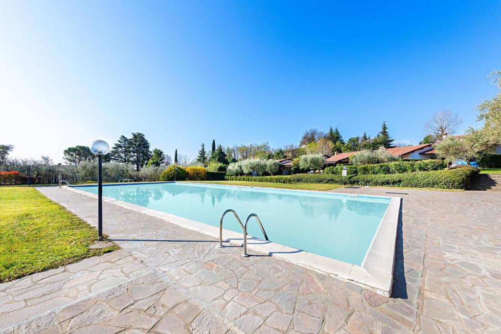 a swimming pool with a light pole next to it at Residence Elena 19-B by Wonderful Italy in Soiano del Lago