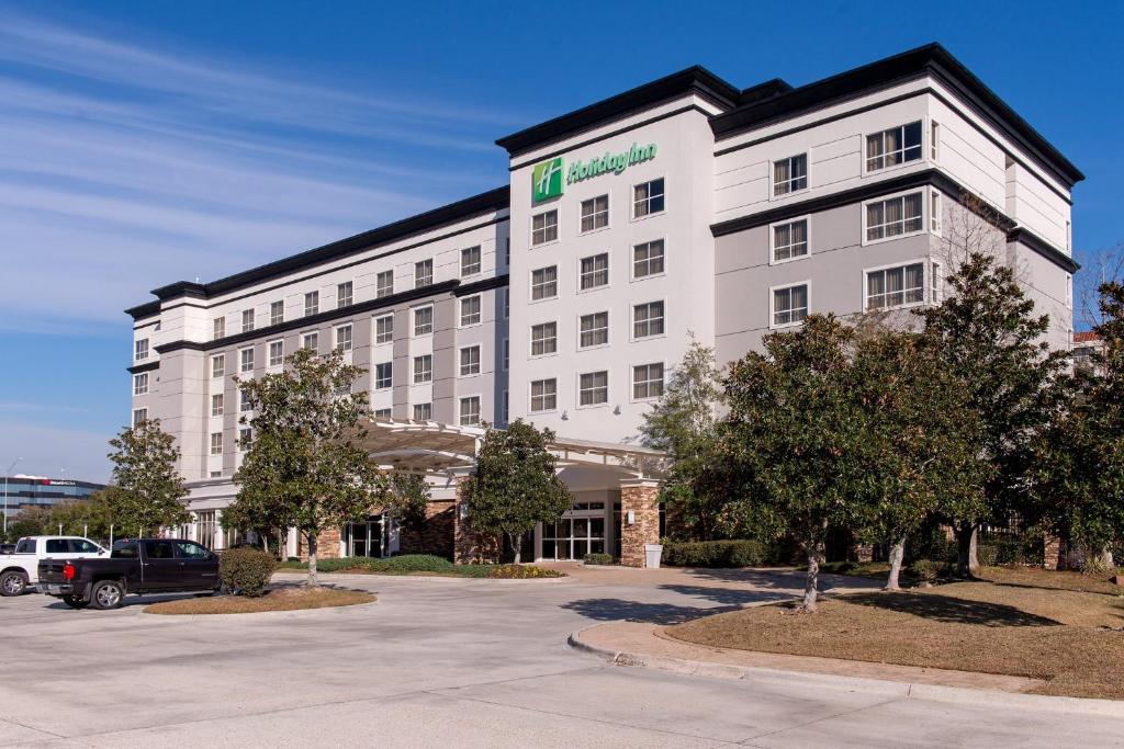 a hotel building with a car parked in a parking lot at Holiday Inn Baton Rouge College Drive I-10, an IHG Hotel in Baton Rouge