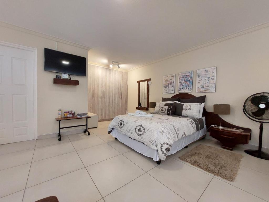Un dormitorio con una cama y un televisor en la pared. en Lyn's Self Catering, en Swakopmund