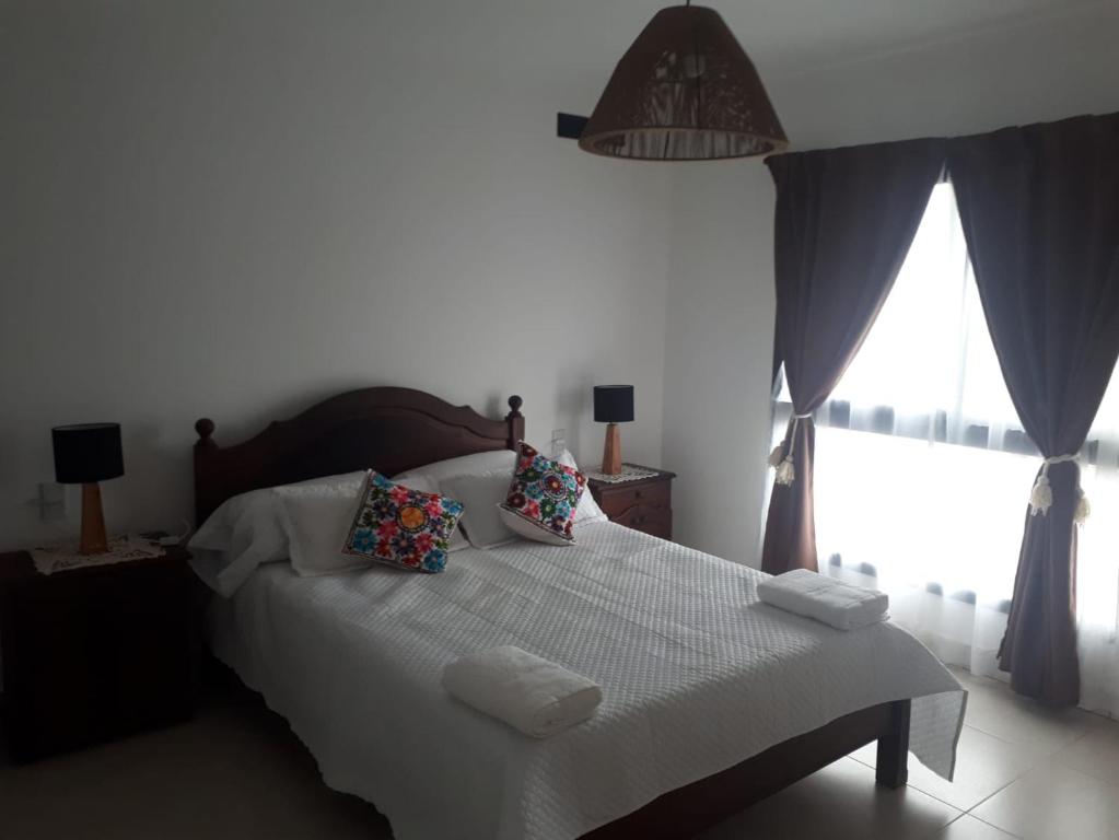 1 dormitorio con 1 cama blanca grande con almohadas en LAYUN.ALOJAMIENTO en San Salvador de Jujuy