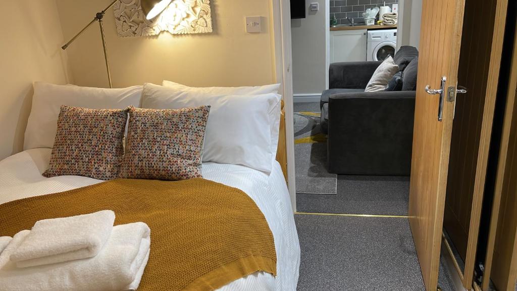 1 dormitorio con cama con almohadas y sofá en Riverside Cottage en Kent
