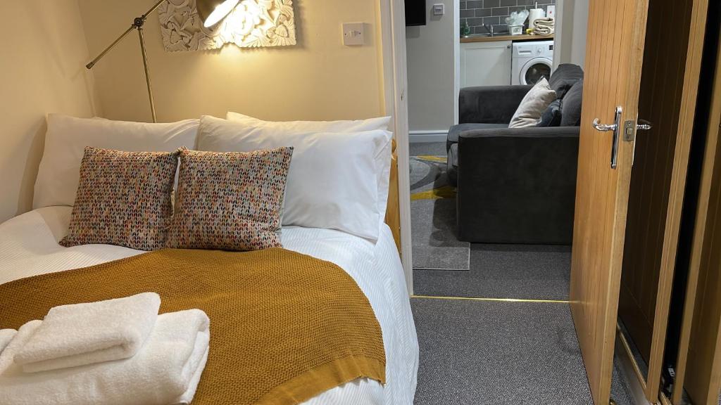 a bedroom with a bed with pillows and a couch at Riverside Cottage in Kent