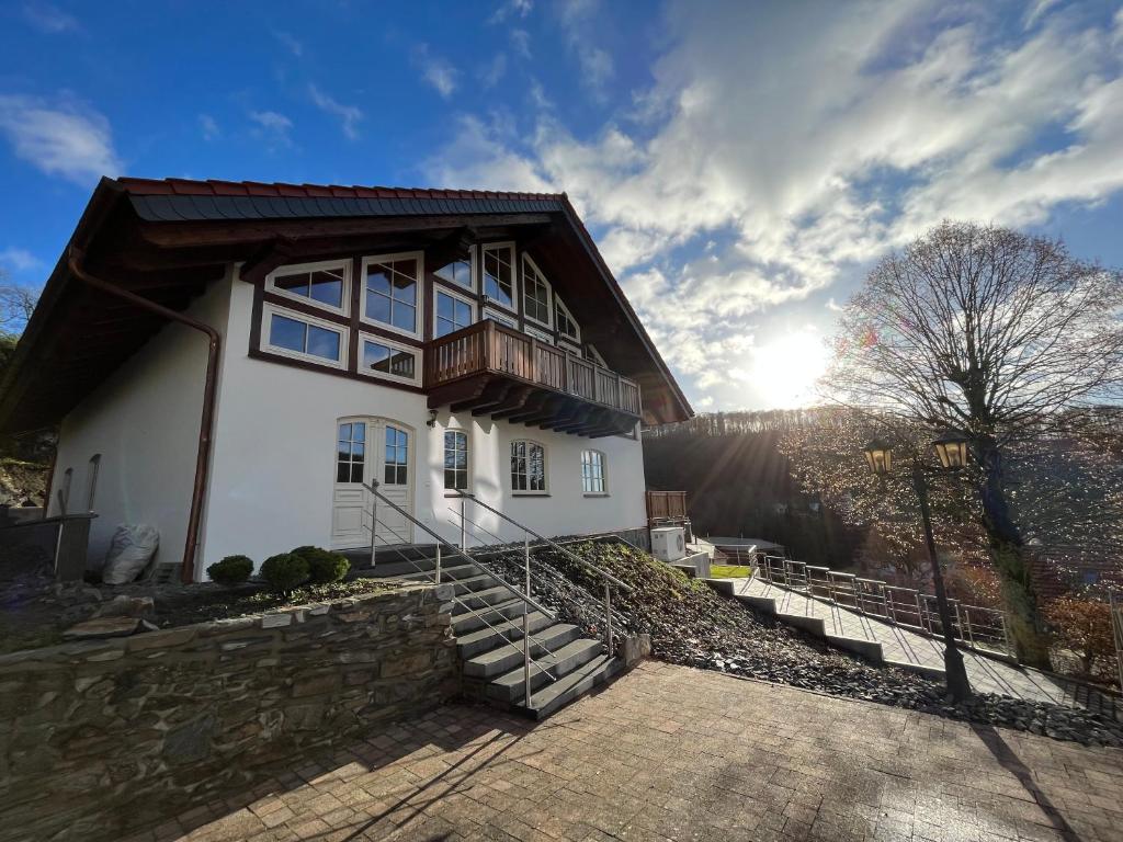 a large white house with a wooden roof at Ferienwohnung Blick Thyratal Obergeschoss in Stolberg i. Harz