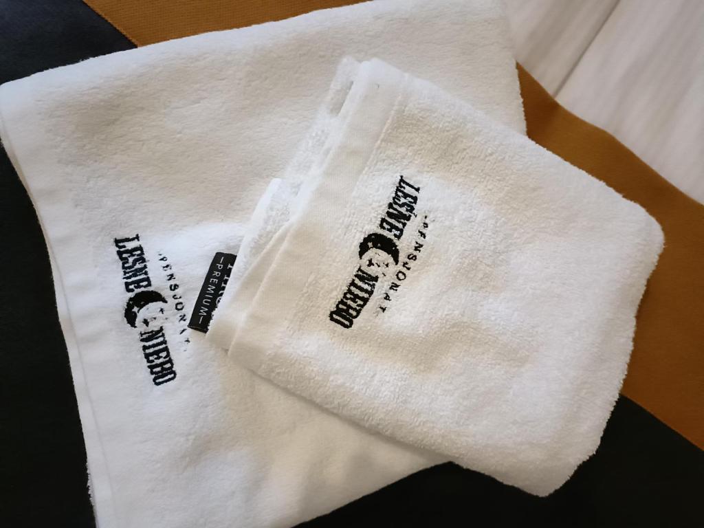 a white towel with three labels on it at Leśne Niebo in Lubniewice