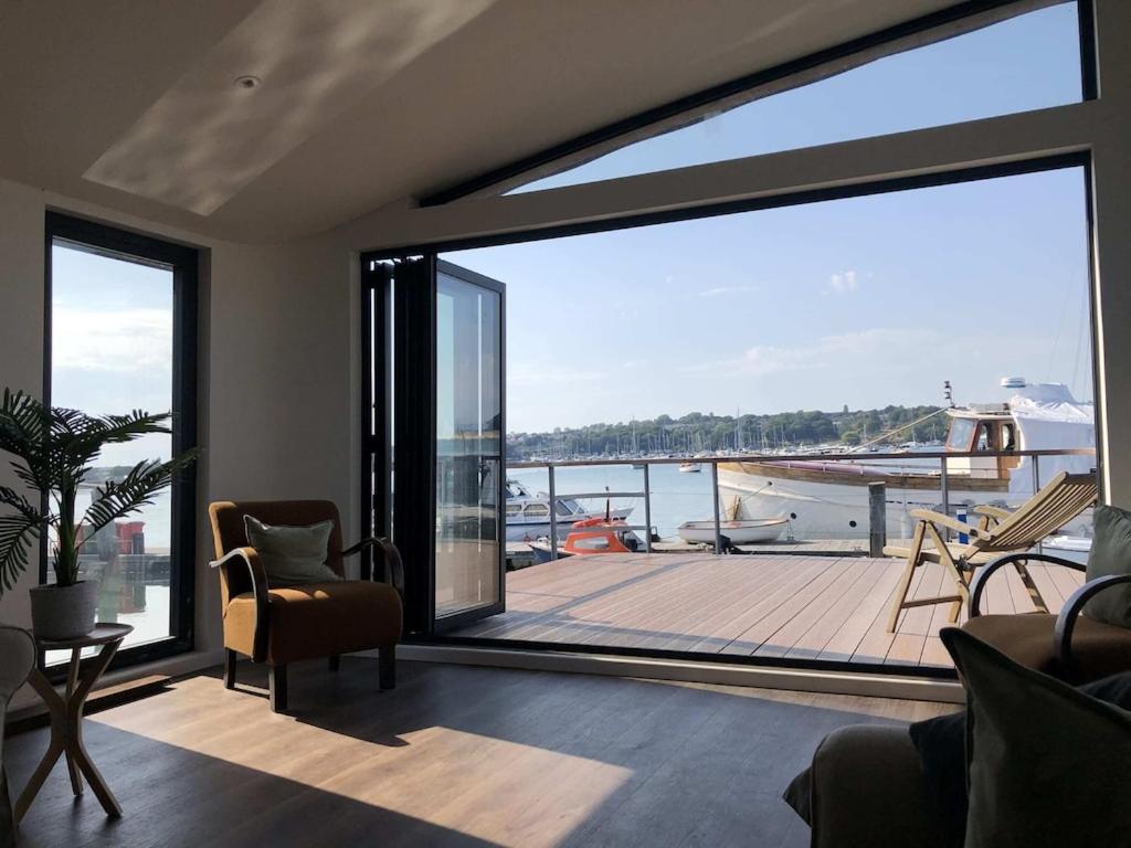 a living room with a large window with a view of a dock at Houseboat Eleuthera in Bembridge