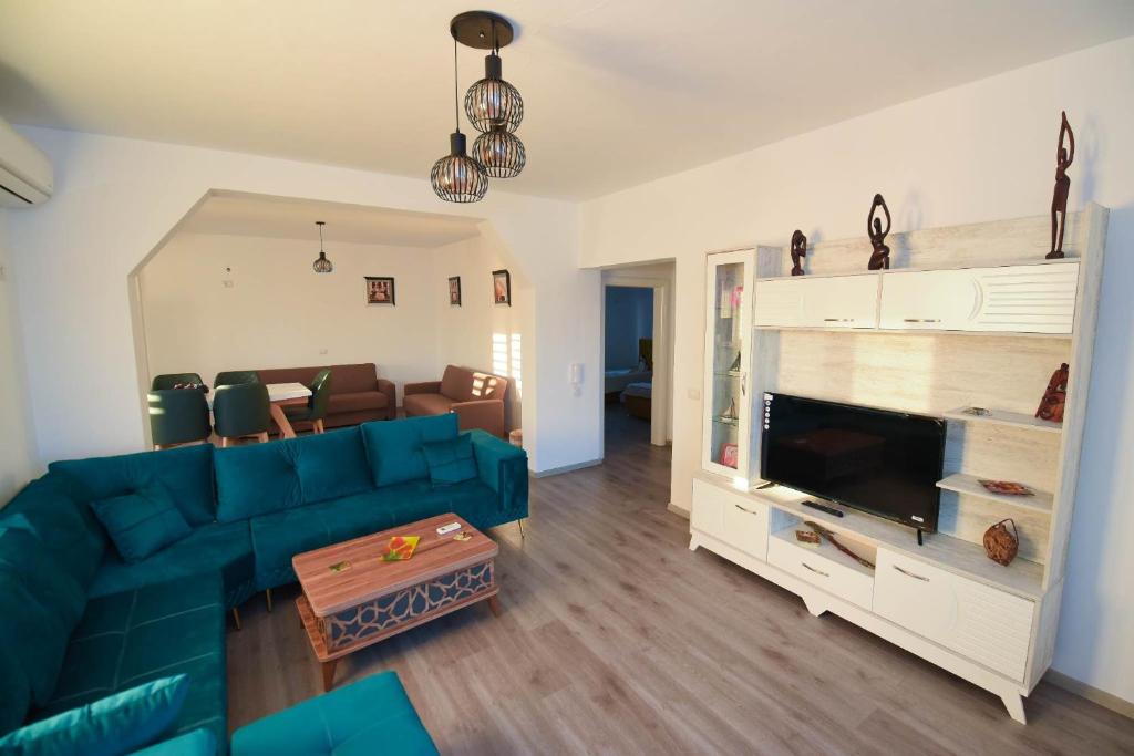 a living room with a blue couch and a television at Vila Emma in Durrës
