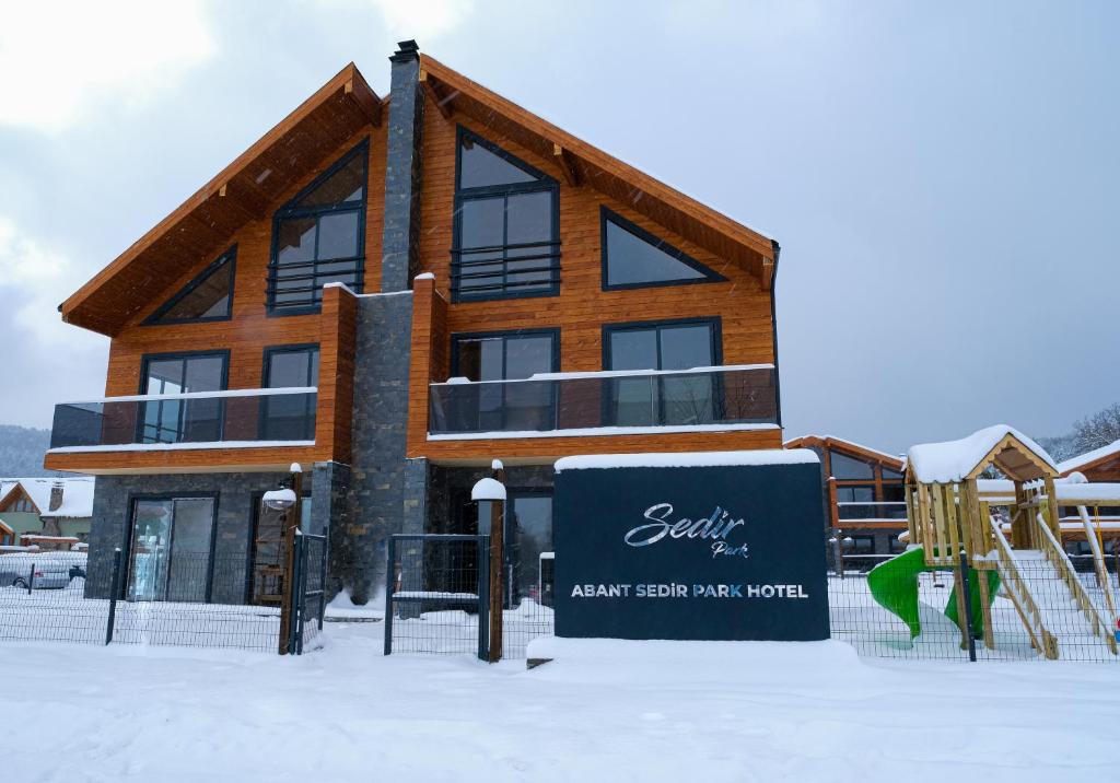 Abant Sedir Park Butik Otel في بولو: مبنى في الثلج مع ملعب
