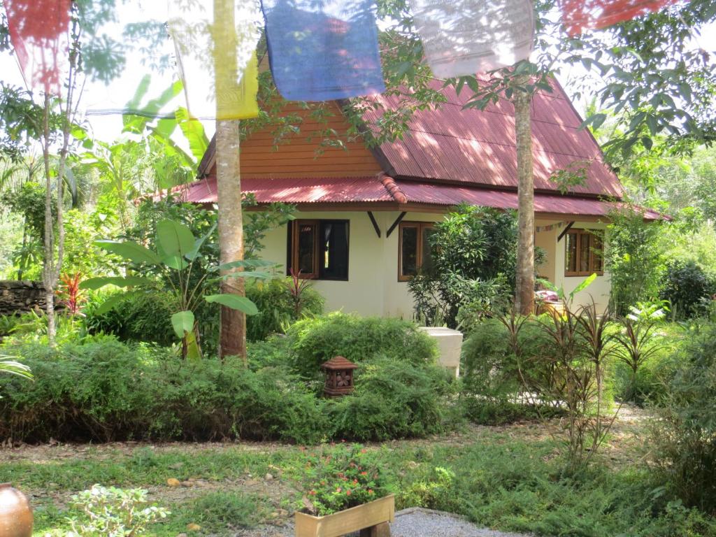 uma pequena casa com um telhado vermelho num jardim em Manora Garden em Phangnga