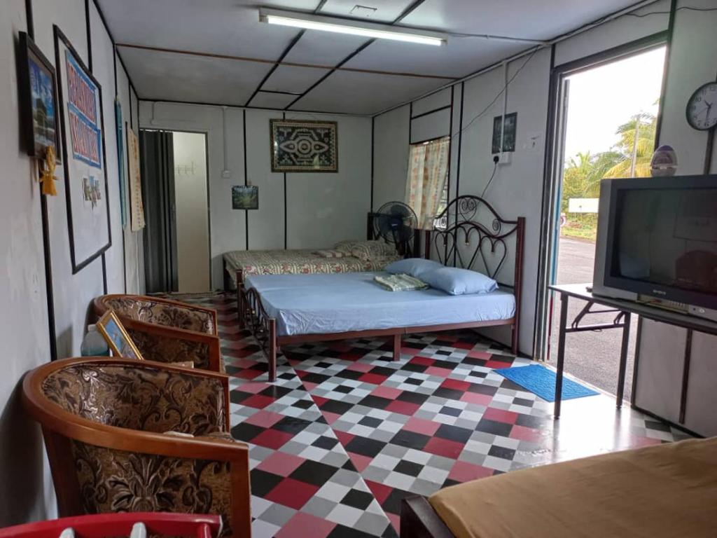 - une chambre avec un lit, une télévision et une table dans l'établissement Tmn Rekreasi Cikgu Haron, à Labis