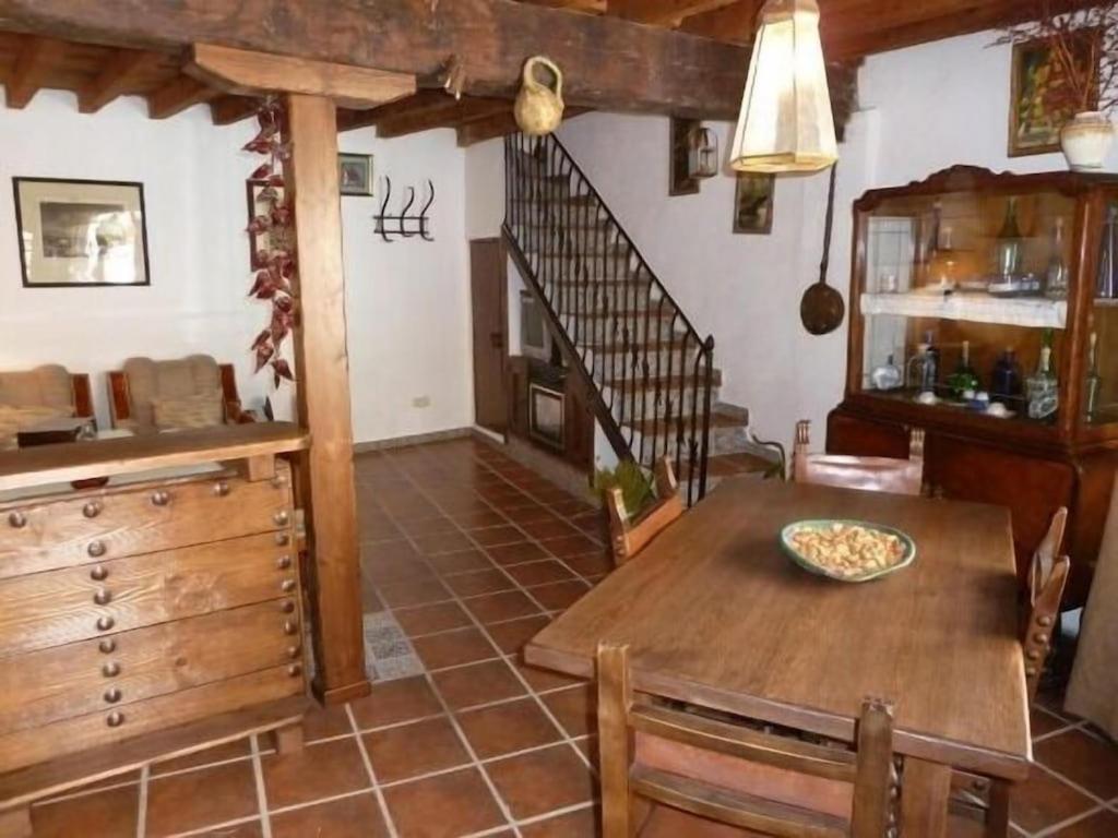 eine Küche und ein Esszimmer mit einem Holztisch in der Unterkunft Casa Montes De Toledo in Marjaliza