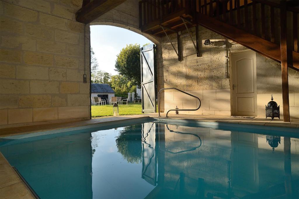 einen Pool in einem Steingebäude mit einem Brunnen in der Unterkunft La Folie Saint Julien in Saint-Julien-de-Chédon