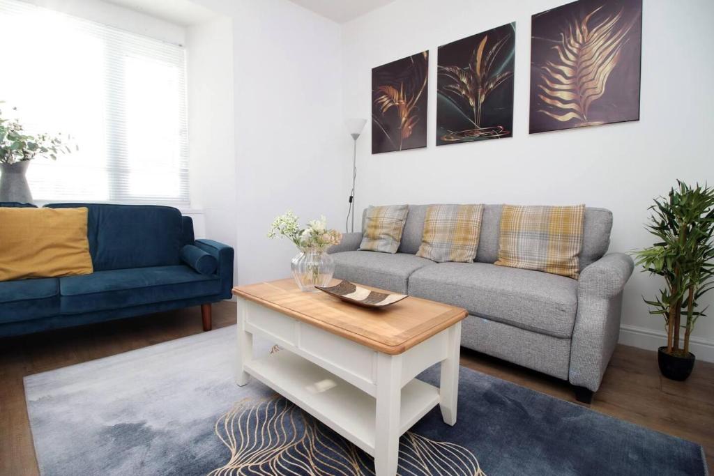 a living room with a couch and a coffee table at Stunning 4 Bedroom Flat near City Centre in Swansea