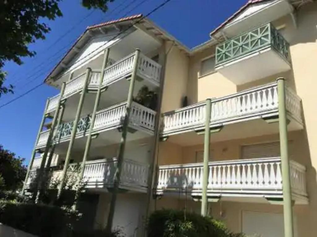 ein großes weißes Gebäude mit Balkonen in der Unterkunft T3 refait à neuf /Plage/Centre/Gare/Terrasse/Pkg/wifi in Arcachon