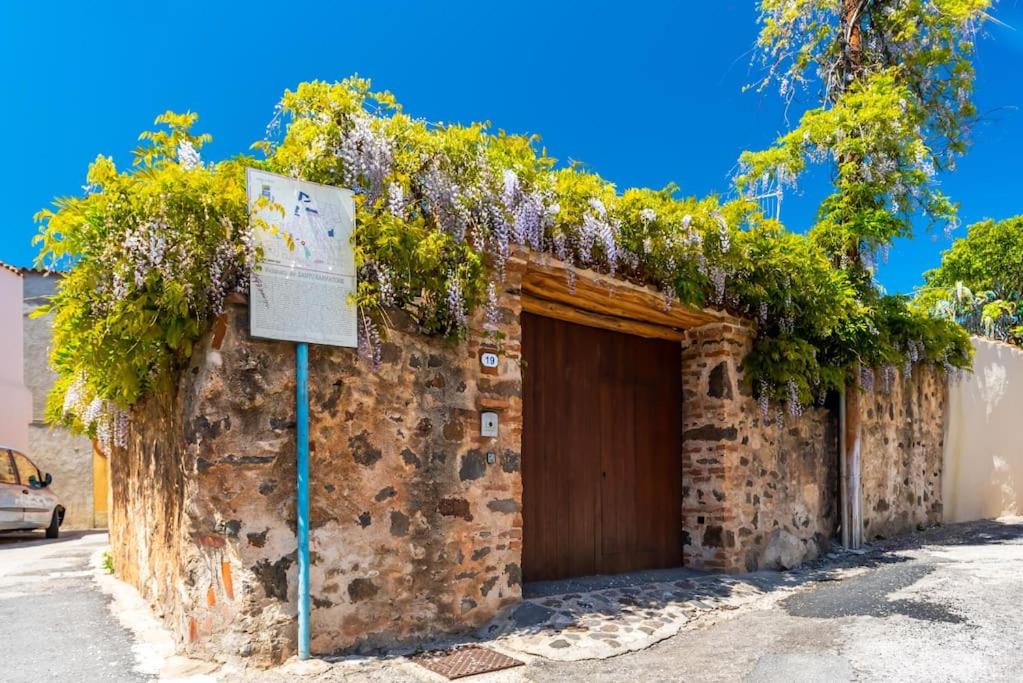 um edifício de tijolos com uma porta com plantas em Beautiful house in Orosei em Orosei