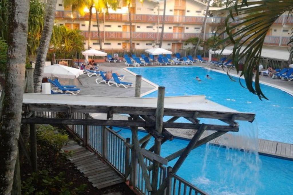 a swimming pool with blue water in a hotel at Ti colibri in Les Trois-Îlets