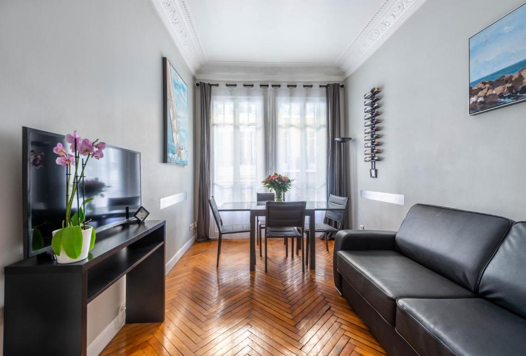 ein Wohnzimmer mit einem Sofa und einem Tisch in der Unterkunft Nice Central Art Deco Flat 45 m² in Nizza