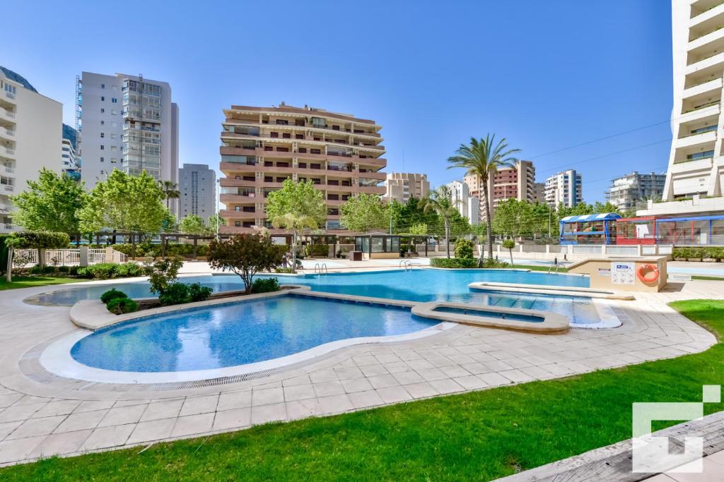 una piscina en medio de un parque con edificios altos en Apartamento Apolo XVI 1 17 - Grupo Turis, en Calpe