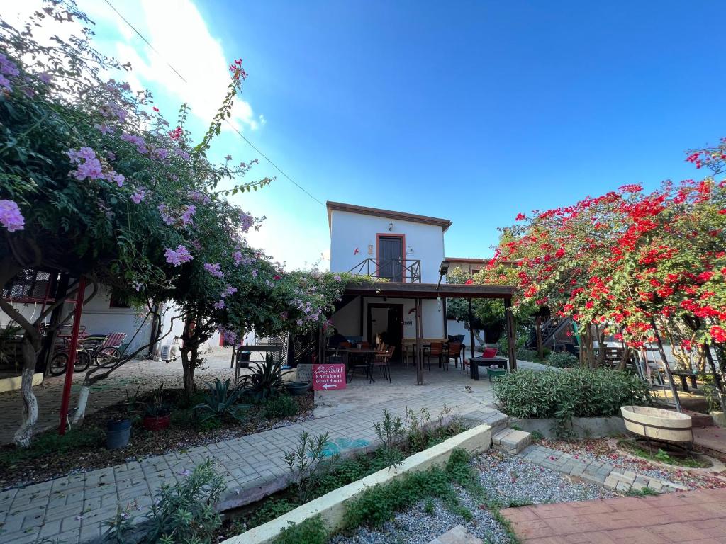 a house with a patio and some trees and flowers at Betul Guest House in Famagusta