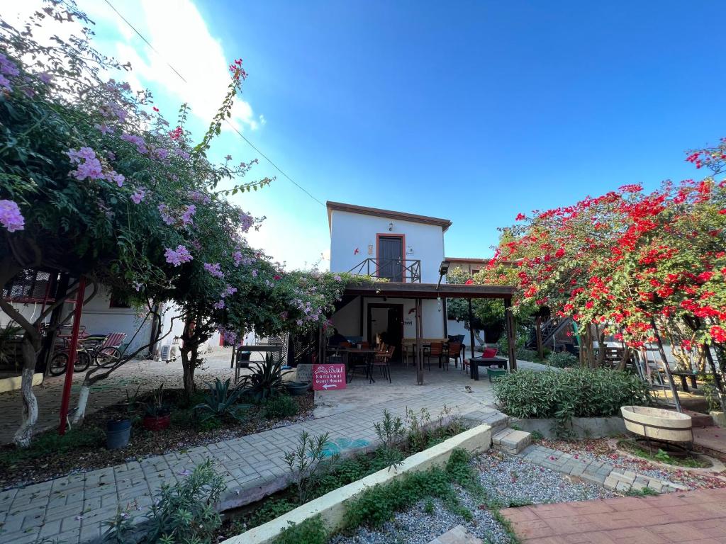 uma casa com um pátio e algumas árvores e flores em Betul Guest House em Famagusta